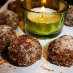 Recette Energy balls aux abricots et aux noix présents sur une assiette avec une bougie