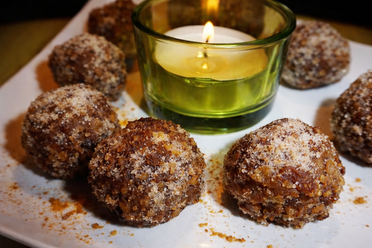 Recette Energy balls aux abricots et aux noix présents sur une assiette avec une bougie