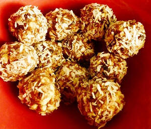 Energy balls de cranberries et cajou enrobées de noix de coco sur une assiette