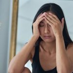 Jeune femme sensible en surcharge mentale qui se tient la tête