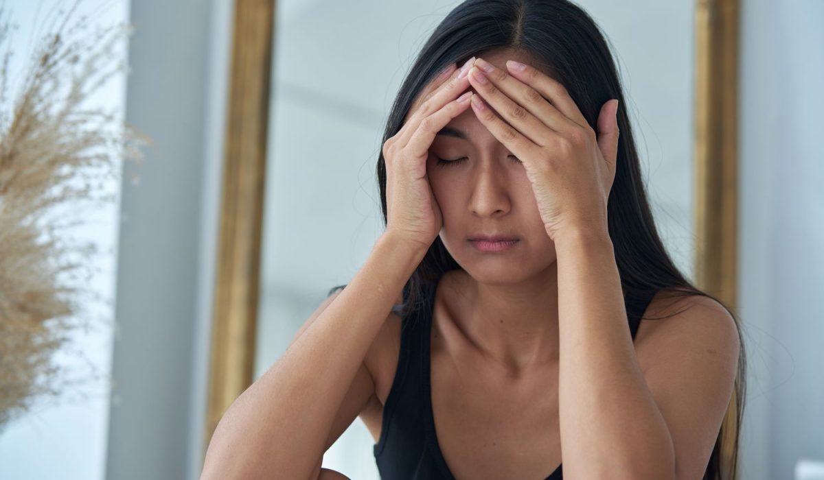 Jeune femme sensible en surcharge mentale qui se tient la tête